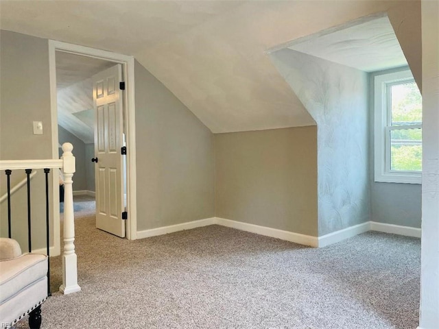 additional living space featuring vaulted ceiling and carpet