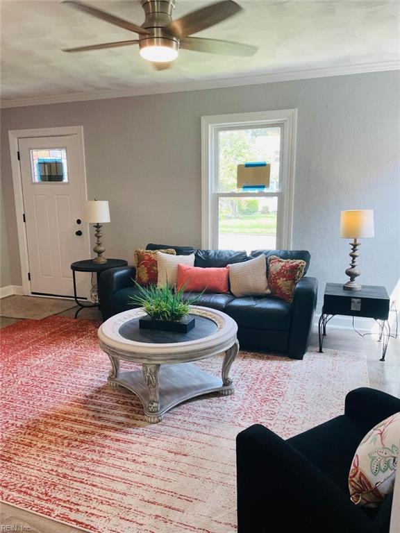 living room with ceiling fan and crown molding