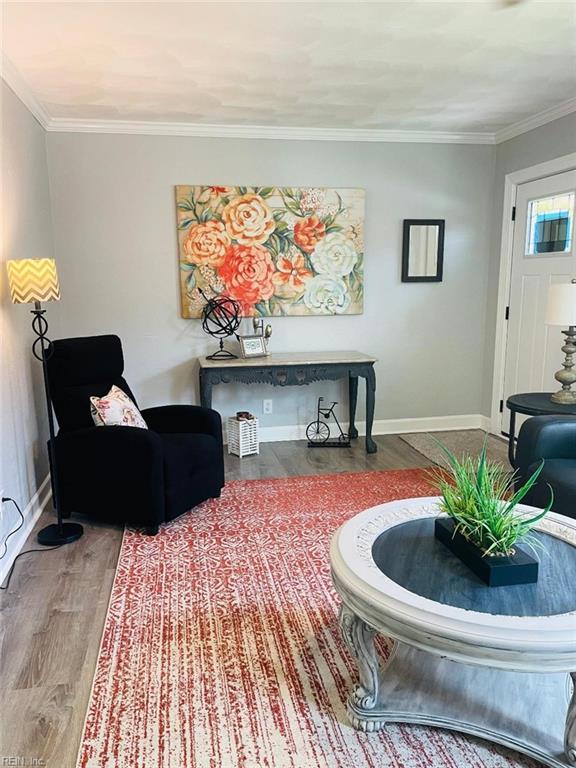 living room with crown molding and hardwood / wood-style flooring