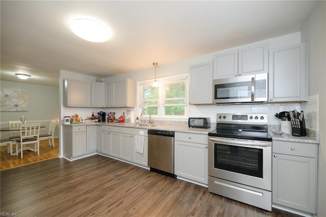 kitchen with sink, stainless steel appliances, dark hardwood / wood-style flooring, white cabinets, and hanging light fixtures