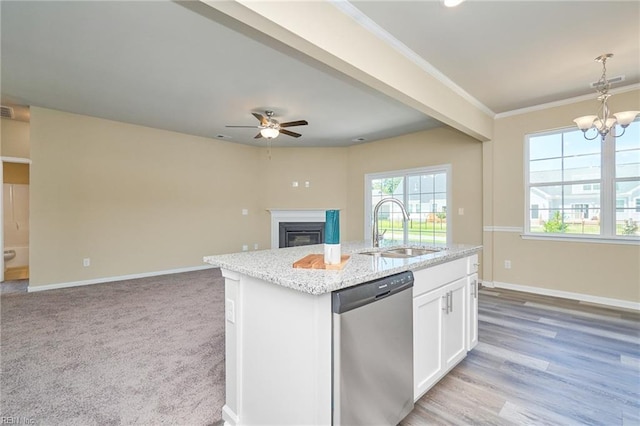 kitchen with white cabinetry, a center island with sink, stainless steel dishwasher, light carpet, and sink