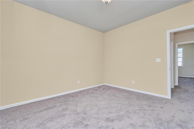 unfurnished room featuring an inviting chandelier, crown molding, and dark carpet