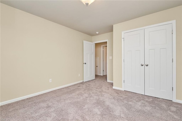 unfurnished bedroom with light carpet and a closet