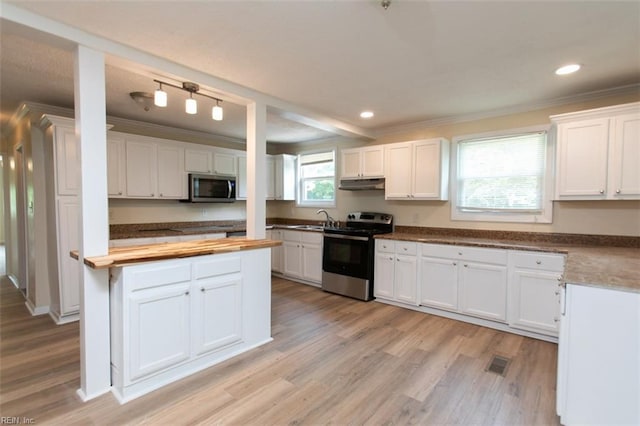 kitchen with butcher block countertops, light wood-type flooring, stainless steel appliances, and white cabinets