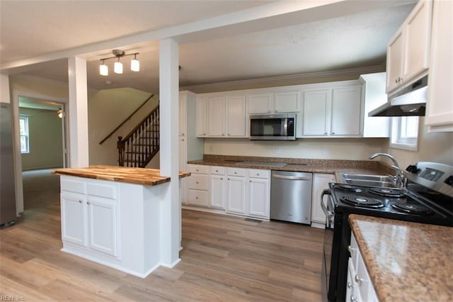 kitchen with sink, white cabinetry, butcher block countertops, and stainless steel appliances