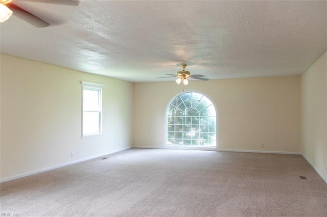 empty room with a textured ceiling, carpet floors, and ceiling fan