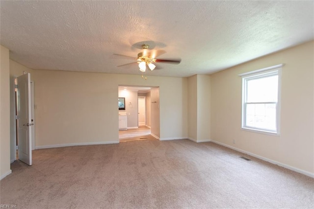 carpeted empty room featuring a textured ceiling and ceiling fan