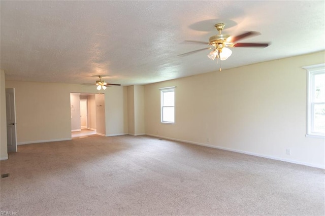 carpeted spare room with a textured ceiling and ceiling fan