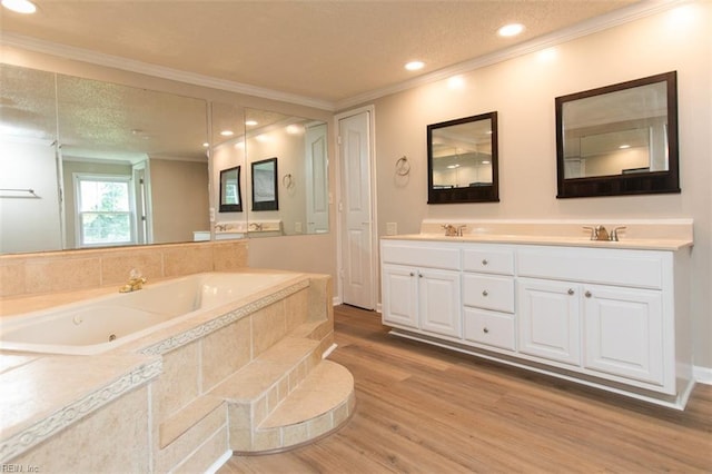 bathroom with tiled tub, dual vanity, hardwood / wood-style flooring, and crown molding