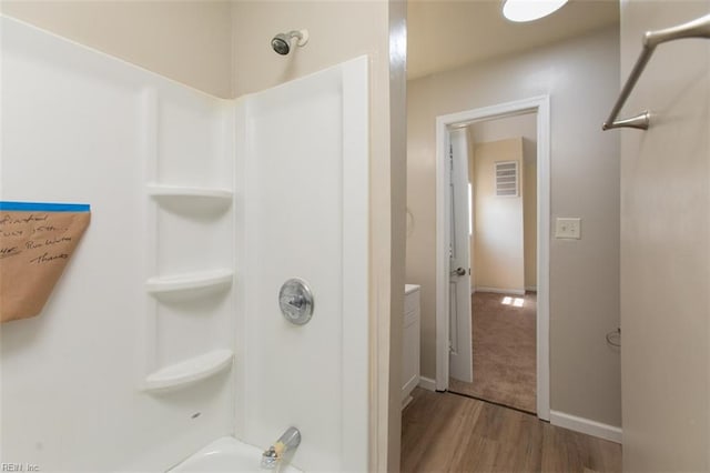 bathroom with hardwood / wood-style floors, shower / washtub combination, and vanity