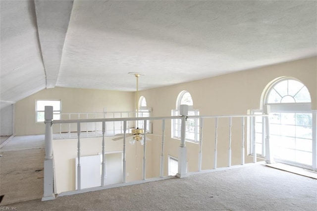 interior space featuring carpet, ceiling fan, and vaulted ceiling