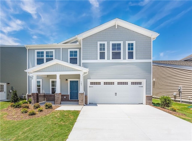 craftsman-style home with a garage, covered porch, and a front yard