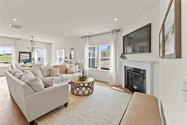 living room featuring an inviting chandelier and light wood-type flooring