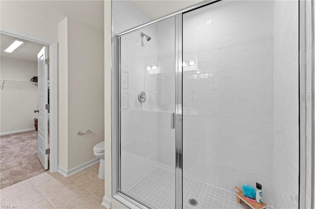 bathroom featuring toilet, an enclosed shower, and tile patterned flooring