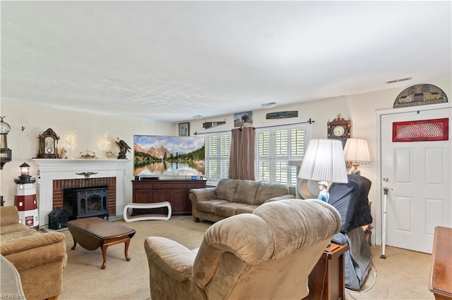 living room featuring a wood stove, light carpet, and a brick fireplace