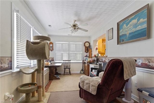 interior space with light carpet, ornamental molding, and ceiling fan