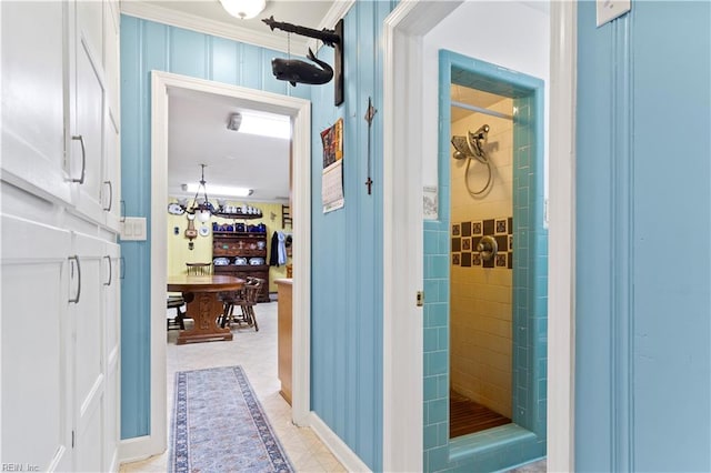 hallway with light tile patterned flooring and crown molding