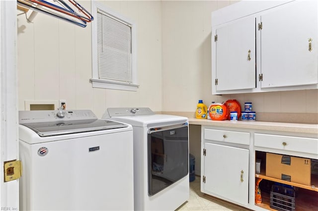 laundry area with washer and clothes dryer, cabinets, and light tile patterned floors