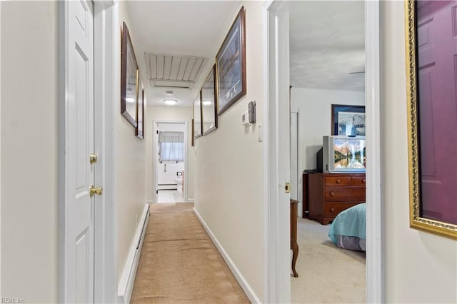 hallway featuring light carpet, baseboards, and a baseboard radiator