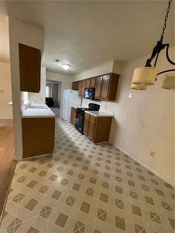 kitchen with black appliances, light countertops, and baseboards