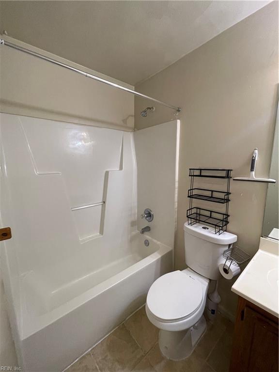 bathroom featuring toilet, bathtub / shower combination, vanity, and tile patterned flooring