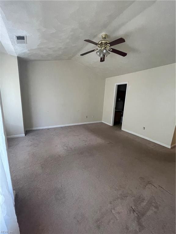 carpeted empty room with lofted ceiling, baseboards, visible vents, and ceiling fan