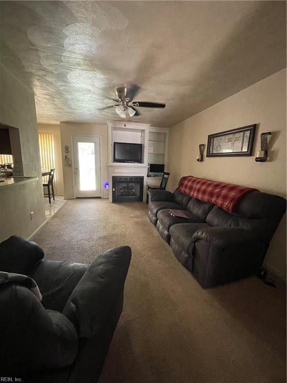 carpeted living room with ceiling fan