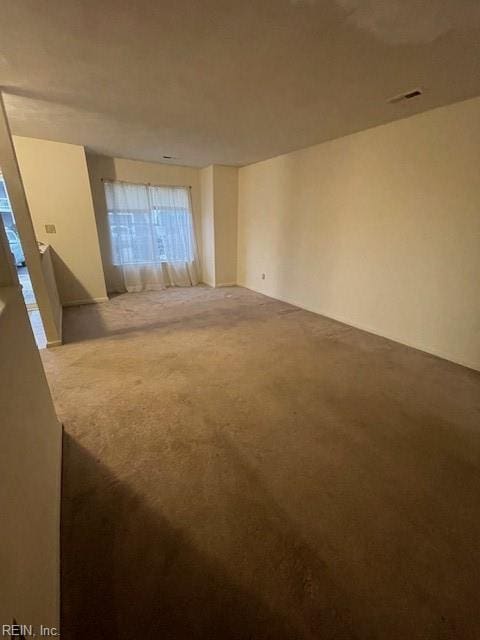 carpeted empty room featuring visible vents