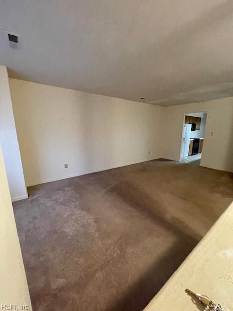 empty room featuring visible vents and dark carpet