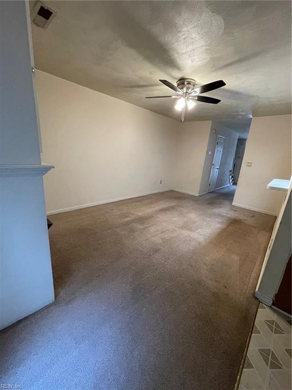 unfurnished living room featuring a ceiling fan, baseboards, visible vents, carpet floors, and a textured ceiling