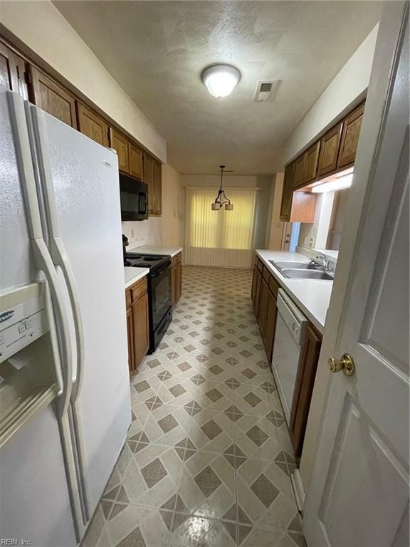 kitchen featuring black appliances, light countertops, visible vents, and a sink