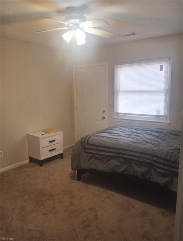 unfurnished bedroom with dark colored carpet and ceiling fan