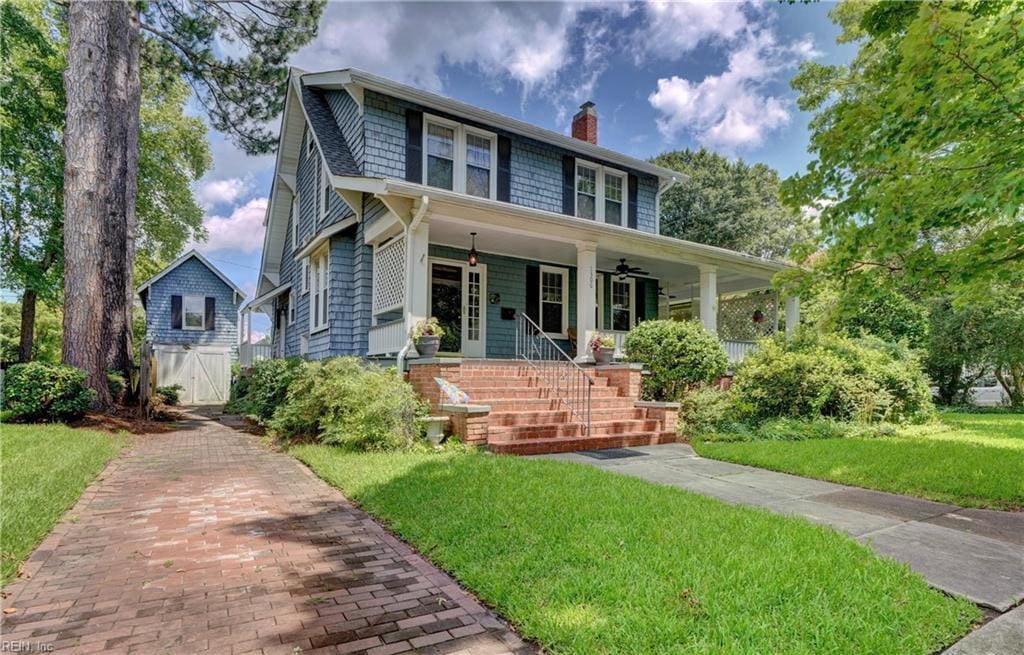 view of front of home featuring a front yard, ceiling fan, and covered porch