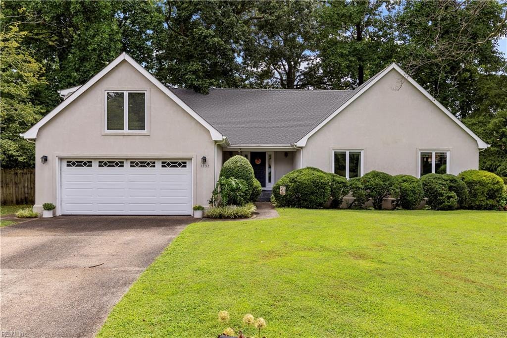 view of front of home with a front yard and a garage