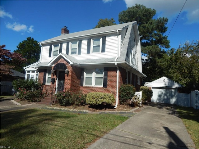 view of front of house featuring a garage, an outbuilding, and a front lawn