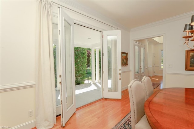 doorway with french doors, crown molding, and light hardwood / wood-style flooring