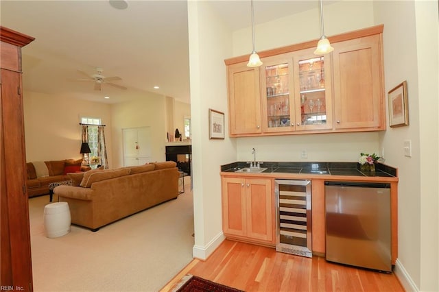 bar featuring sink, hanging light fixtures, fridge, wine cooler, and light brown cabinets