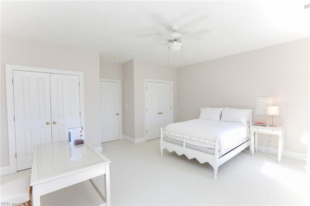 carpeted bedroom featuring two closets and ceiling fan