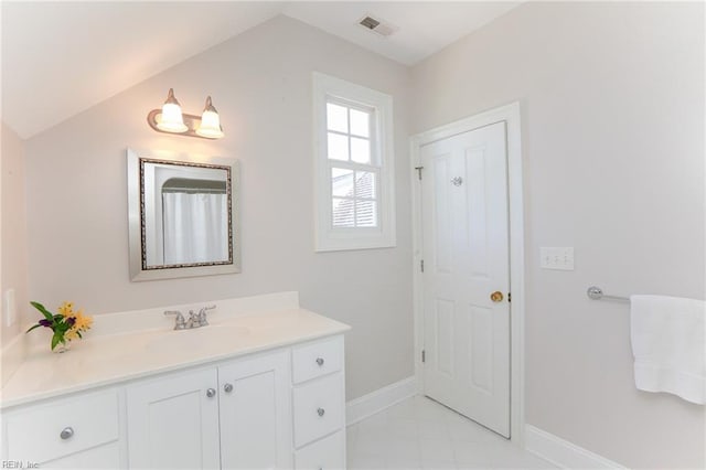 bathroom with vanity and lofted ceiling