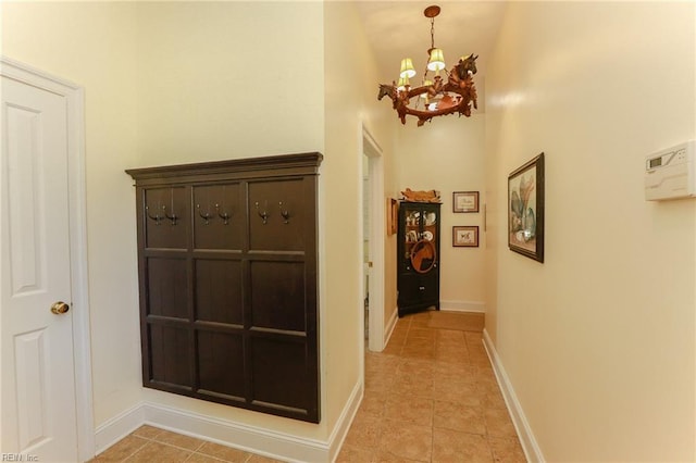 corridor featuring a notable chandelier and light tile patterned flooring