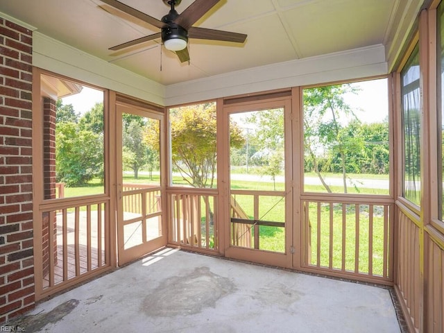 unfurnished sunroom with ceiling fan