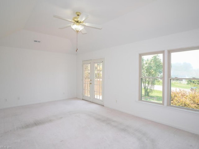 carpeted spare room featuring french doors, ceiling fan, and a tray ceiling