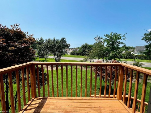 wooden deck featuring a lawn