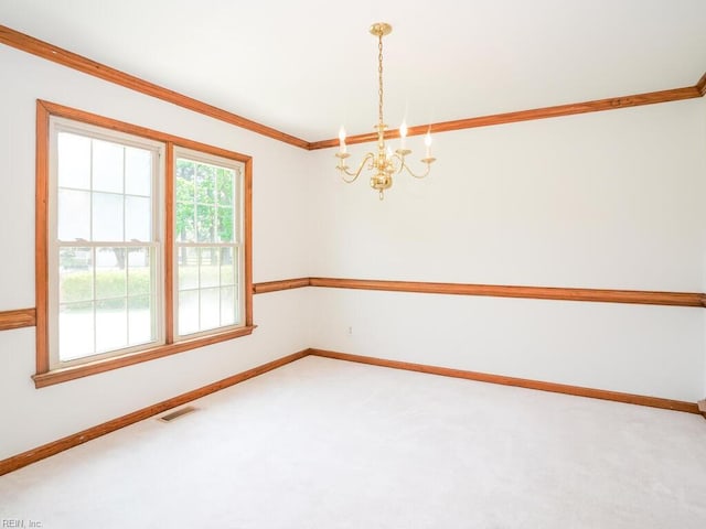 carpeted spare room with a notable chandelier and crown molding