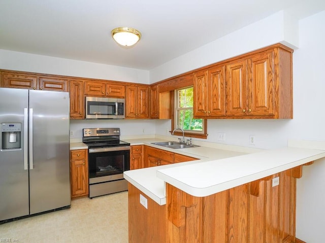 kitchen with sink, stainless steel appliances, kitchen peninsula, and a kitchen bar