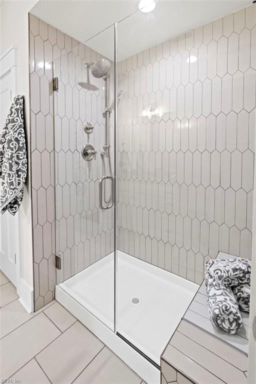 bathroom with tile patterned flooring and a shower stall