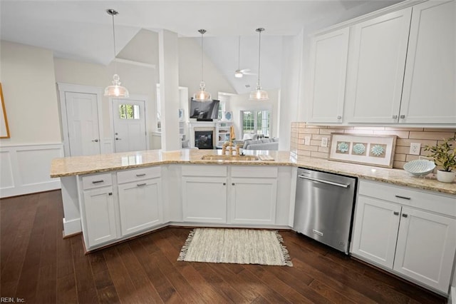 kitchen with dark wood-type flooring, a sink, white cabinetry, stainless steel dishwasher, and a glass covered fireplace