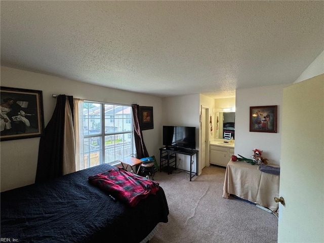 carpeted bedroom with ensuite bath and a textured ceiling