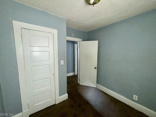 unfurnished bedroom featuring baseboards and a textured ceiling