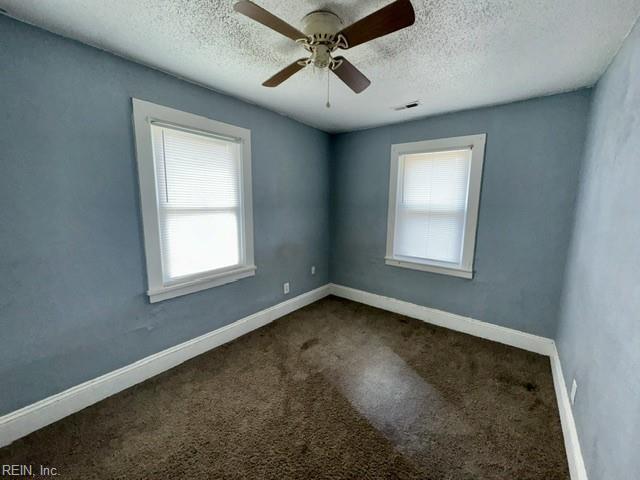 1030 37th St, Newport News, VA 23607 - spare room with a textured ceiling, baseboards, and dark colored carpet